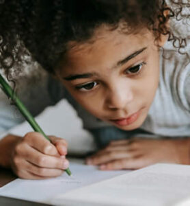 une enfant essaie d'écrire